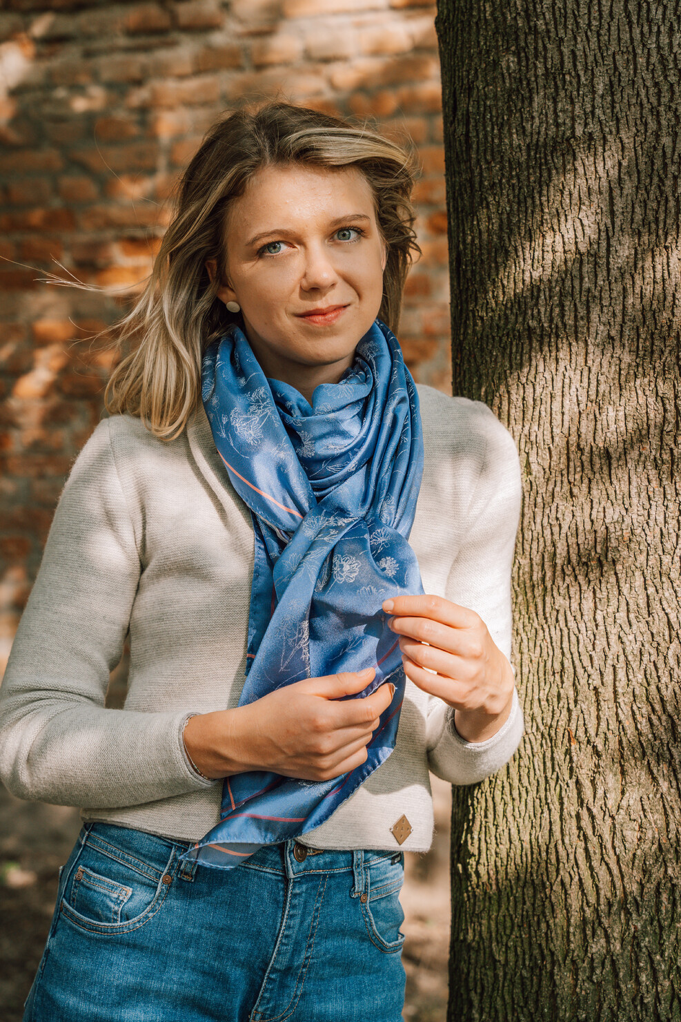 Frau mit blauem Seidenschal FLORA aus nachhaltiger Produktion – regional gewebt in Wien aus reiner Jacquard-Seide.